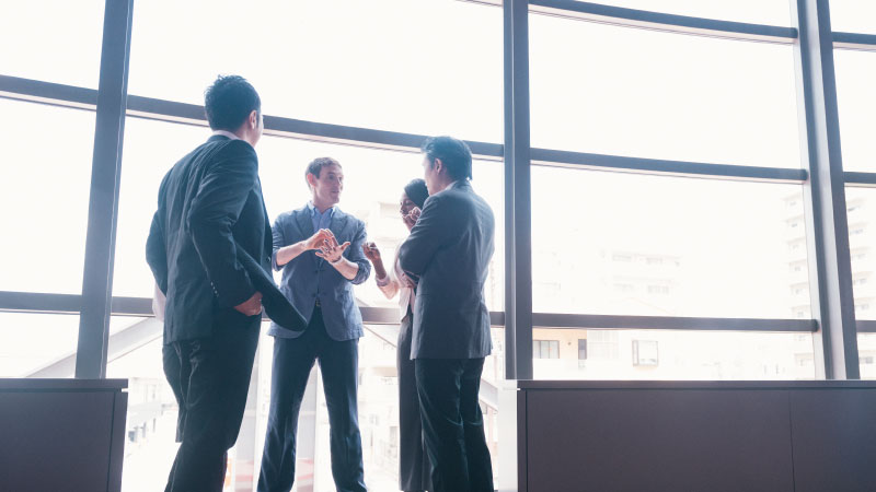Person proposing an idea or elevator pitch to a group of three people