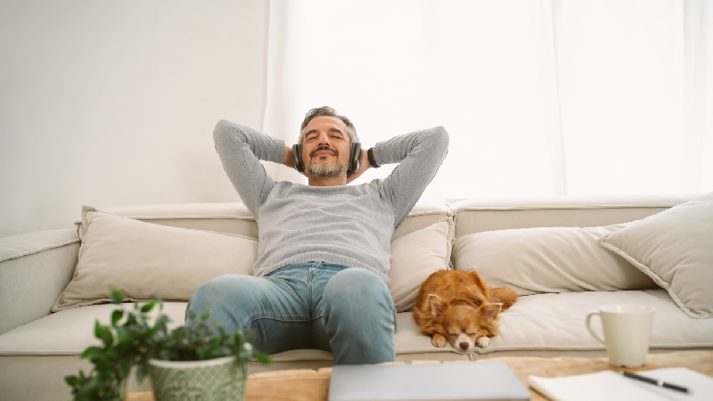 man relaxing while listening to music on headphone