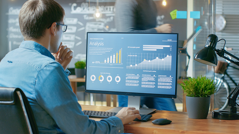 Person using PSA software showing a dashboard with data analysis on a desktop computer