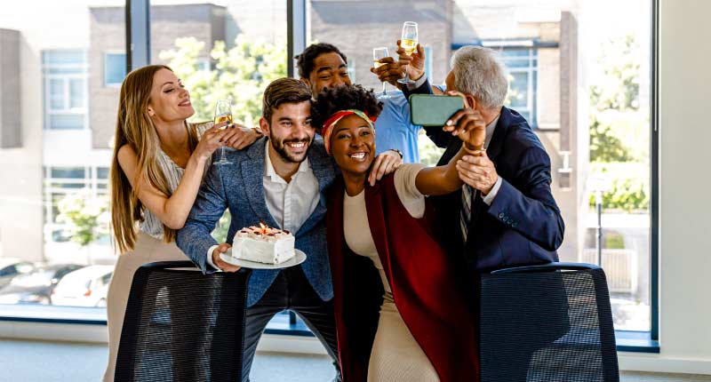  excited workers celebrating together and taking a selfie