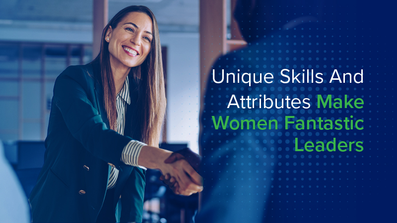 A woman in a business suit shaking hands with a person of color in the workplace