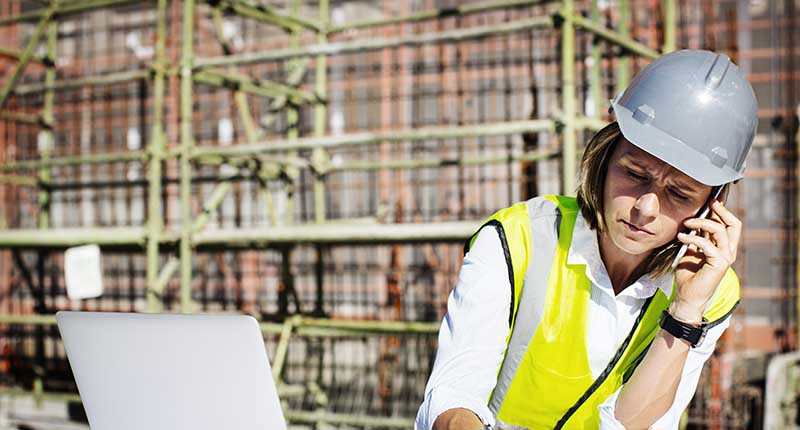 Female architect using mobile phone while working at a construction site 
