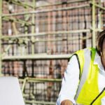 Female architect using mobile phone while working at construction site