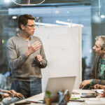 Mid adult manager talking while having presentation with his team in the office