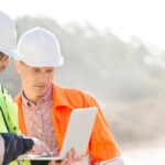 Two managers using AI workforce management software on a laptop