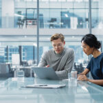 A team of two consultants discussing consulting pricing models